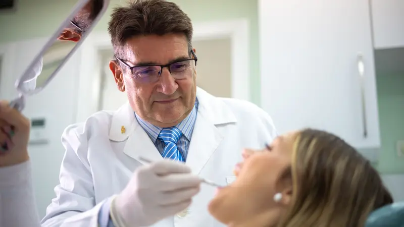 El doctor revisa la boca de una paciente